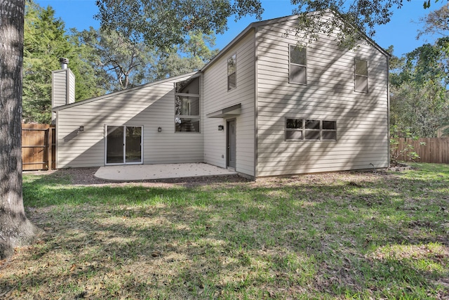 rear view of house with a lawn and a patio