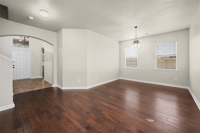 spare room featuring dark hardwood / wood-style floors and a textured ceiling