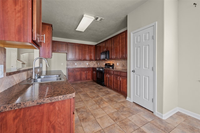 kitchen with backsplash, black appliances, sink, light tile patterned floors, and a textured ceiling