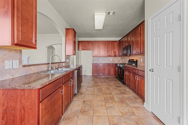 kitchen with sink, backsplash, a textured ceiling, light tile patterned floors, and black appliances