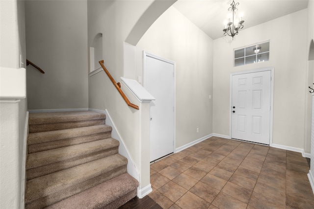 foyer entrance featuring a towering ceiling and an inviting chandelier