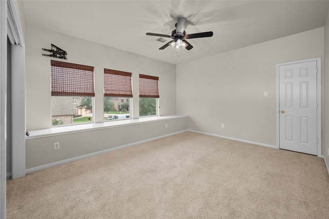 empty room featuring ceiling fan and light colored carpet