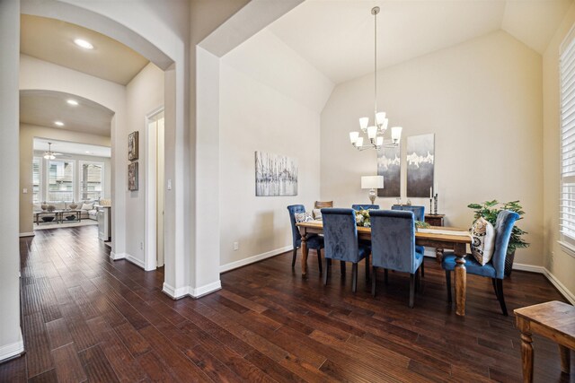 dining area with dark hardwood / wood-style floors, vaulted ceiling, and a notable chandelier