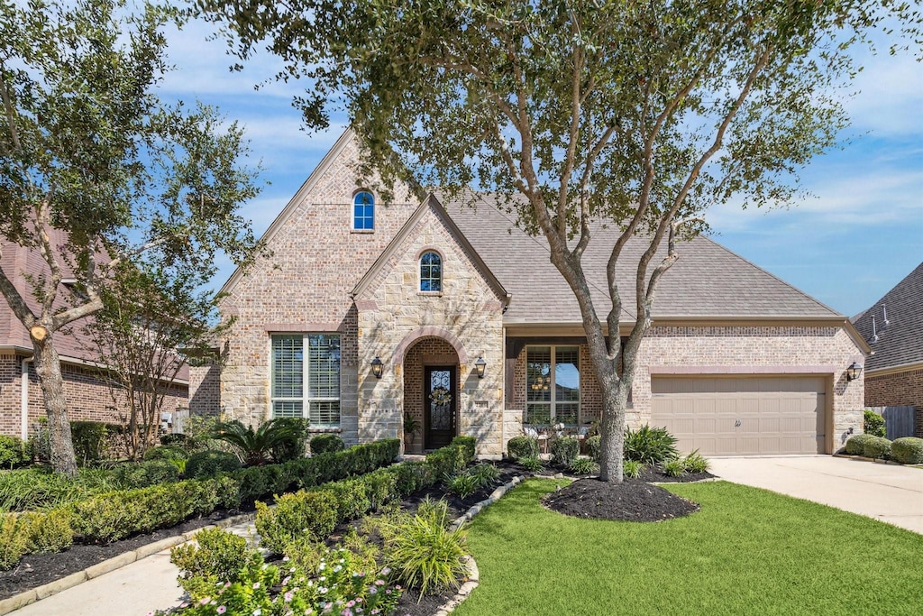 view of front of house with a garage and a front lawn