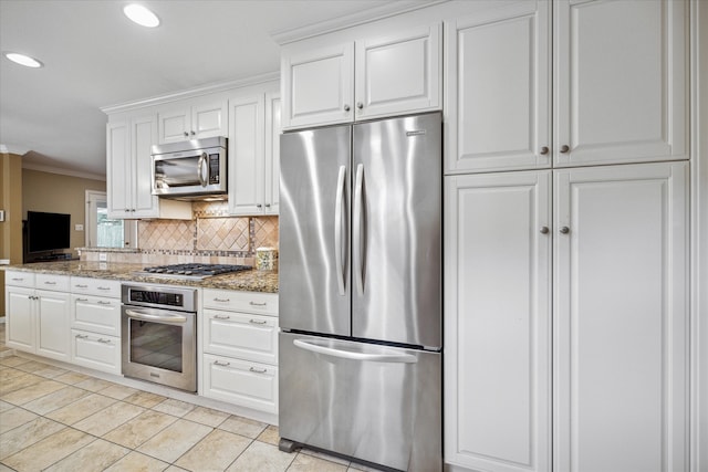 kitchen with crown molding, light stone countertops, white cabinets, light tile patterned floors, and appliances with stainless steel finishes