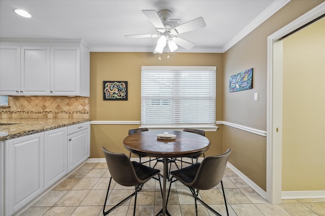 tiled dining room featuring ornamental molding and ceiling fan