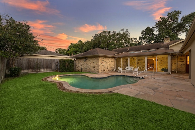 pool at dusk featuring a yard and a patio