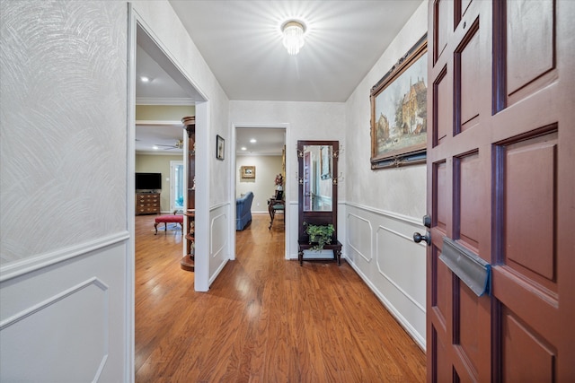 foyer with light hardwood / wood-style floors, ornamental molding, and ceiling fan