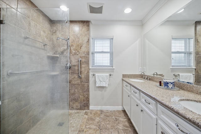 bathroom with vanity, a tile shower, and a healthy amount of sunlight