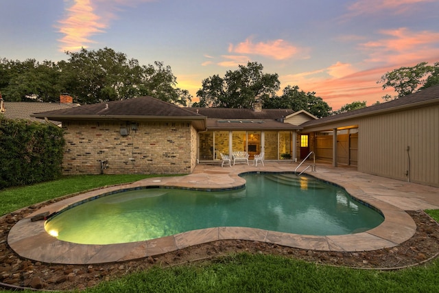 pool at dusk with a patio area