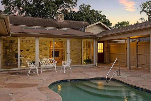 pool at dusk with a patio