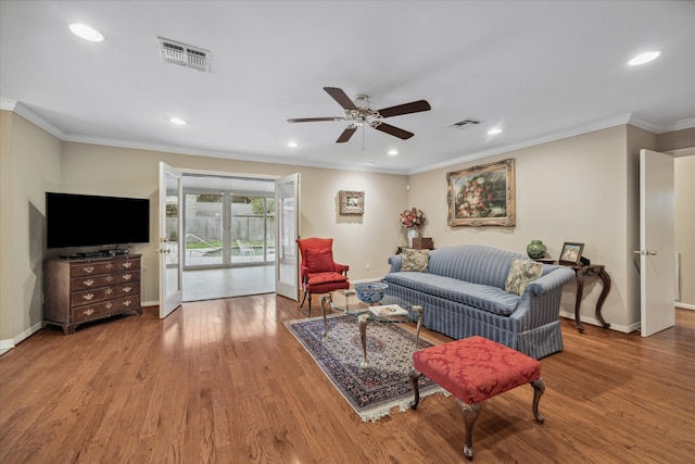 living room with ceiling fan, crown molding, and hardwood / wood-style floors