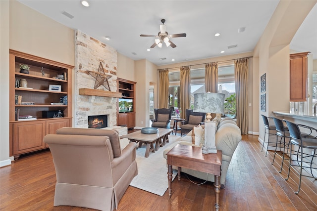 living room with hardwood / wood-style floors, a fireplace, and ceiling fan