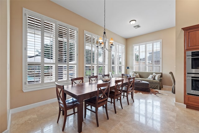 dining room with a notable chandelier and light tile patterned floors