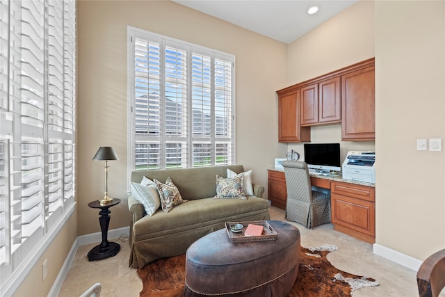 office with light carpet, built in desk, and a wealth of natural light