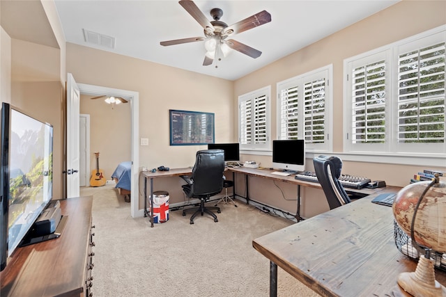 carpeted home office featuring ceiling fan