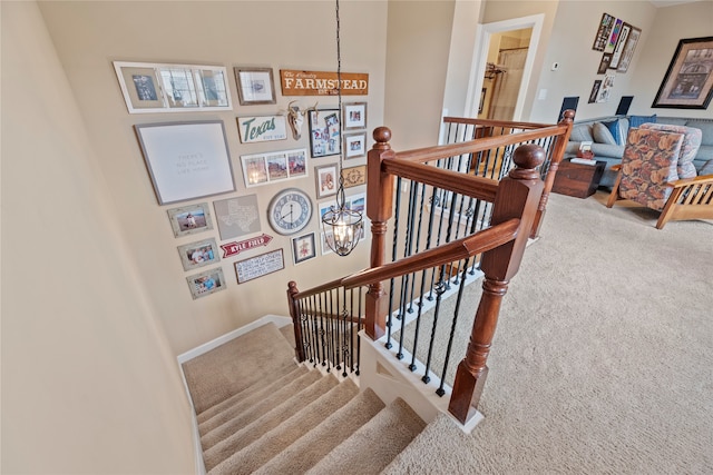 stairs featuring carpet floors and a chandelier