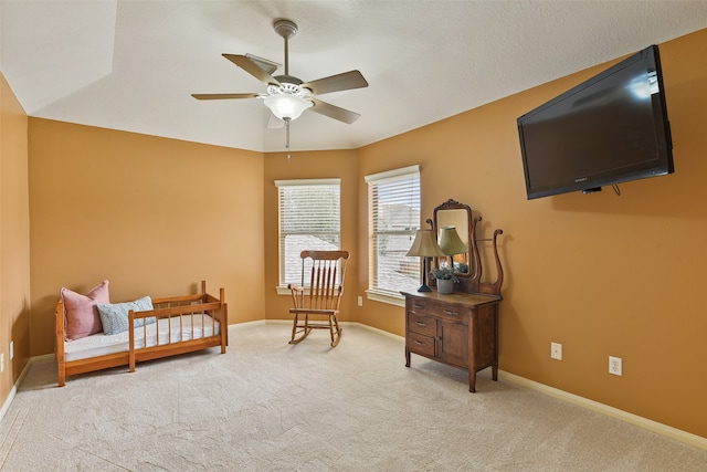 living area featuring light carpet and ceiling fan