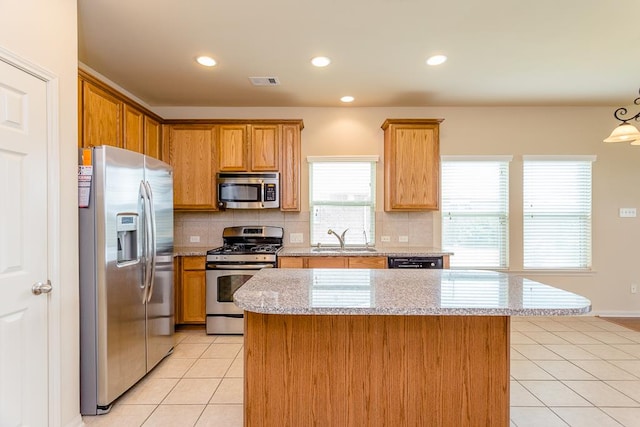 kitchen with a center island, tasteful backsplash, stainless steel appliances, and sink