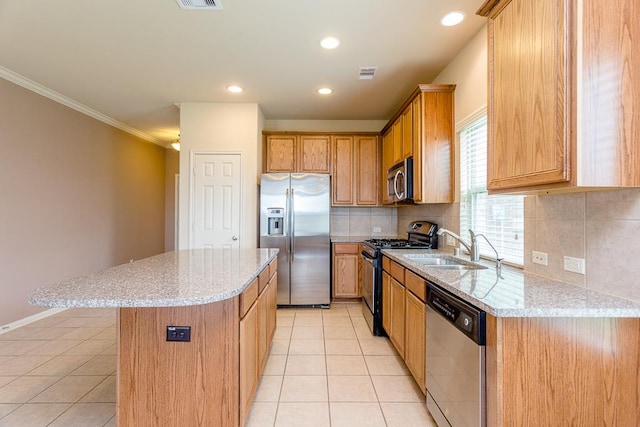 kitchen with decorative backsplash, a kitchen island, appliances with stainless steel finishes, crown molding, and sink