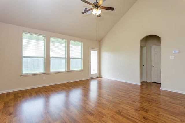 spare room with hardwood / wood-style flooring, high vaulted ceiling, and ceiling fan