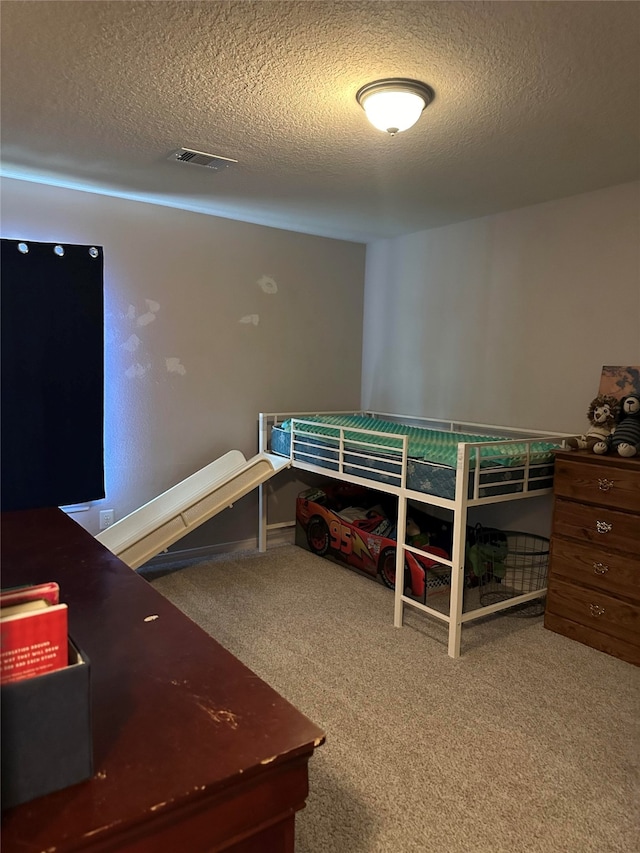 bedroom featuring carpet flooring and a textured ceiling