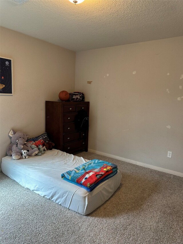 carpeted bedroom featuring a textured ceiling