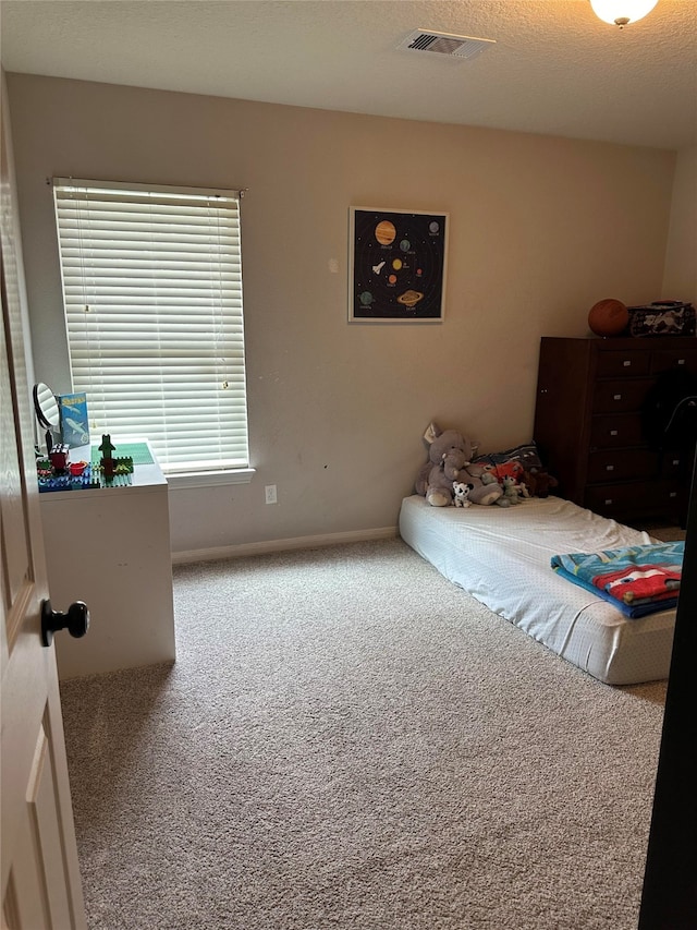 carpeted bedroom with a textured ceiling