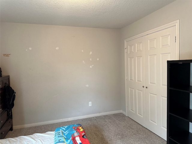 unfurnished bedroom featuring light carpet, a textured ceiling, and a closet