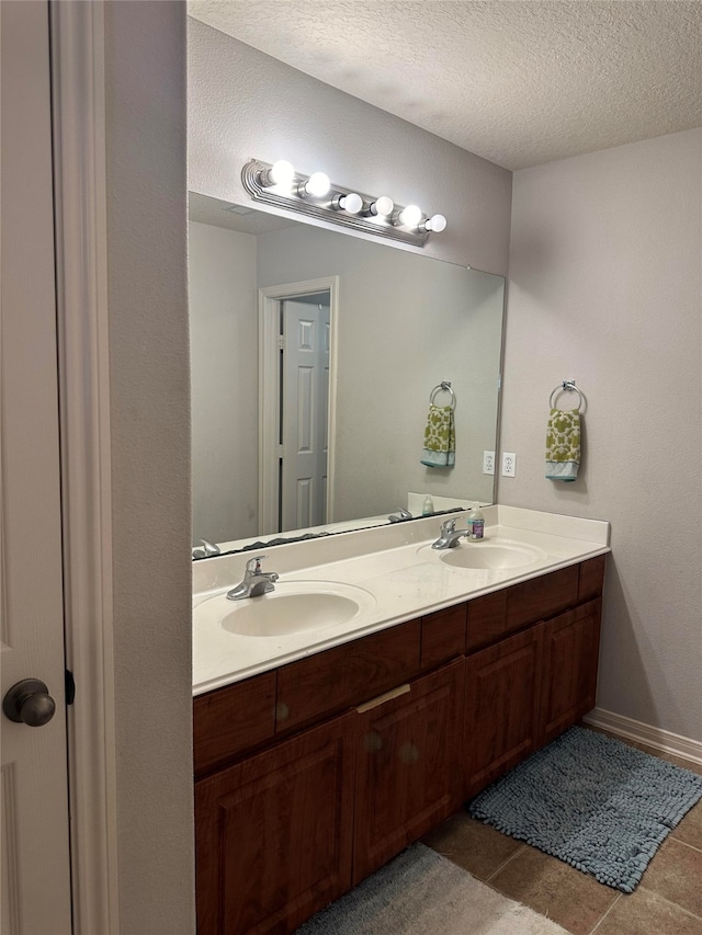 bathroom featuring tile patterned floors, vanity, and a textured ceiling