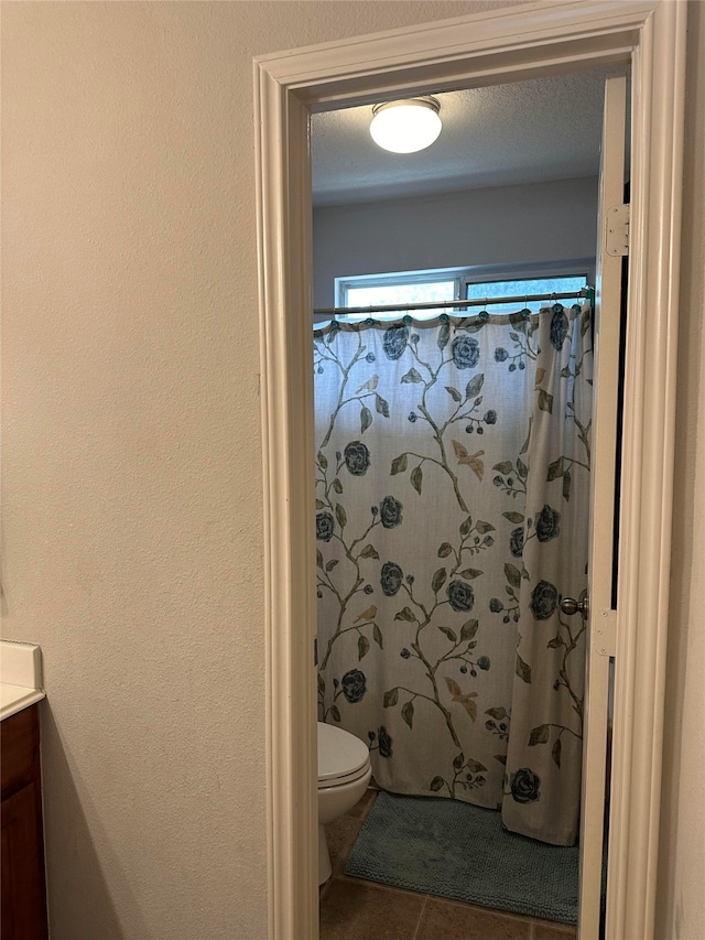 bathroom featuring curtained shower, vanity, a textured ceiling, and toilet