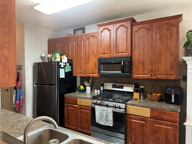 kitchen with decorative backsplash, sink, black appliances, and a textured ceiling