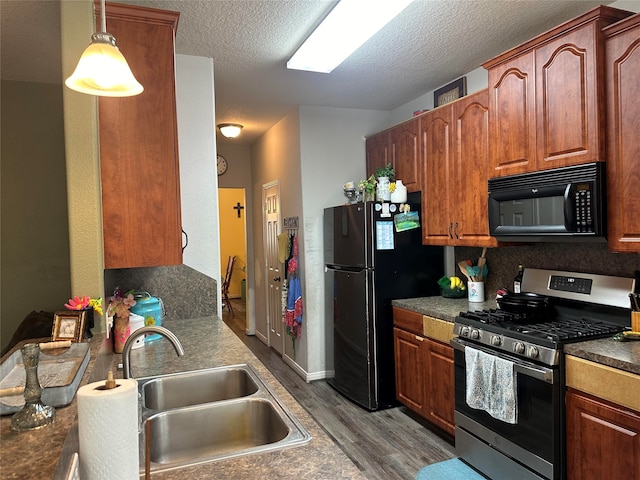 kitchen with sink, hanging light fixtures, hardwood / wood-style floors, a textured ceiling, and black appliances