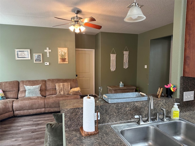 kitchen with ceiling fan, sink, a textured ceiling, and hardwood / wood-style flooring