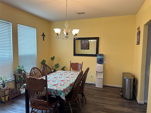 dining space with dark hardwood / wood-style floors and a notable chandelier