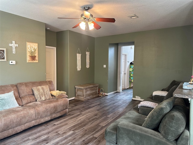 living room with ceiling fan, dark hardwood / wood-style flooring, and a textured ceiling