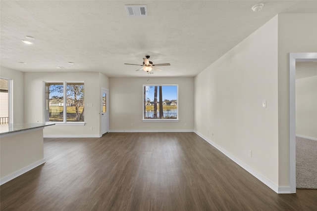 unfurnished living room with ceiling fan and dark hardwood / wood-style floors