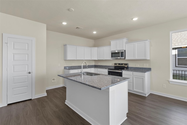 kitchen with an island with sink, stainless steel appliances, white cabinetry, and sink