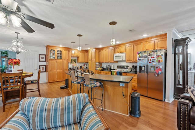 kitchen featuring a kitchen bar, light wood-type flooring, stainless steel appliances, and a center island