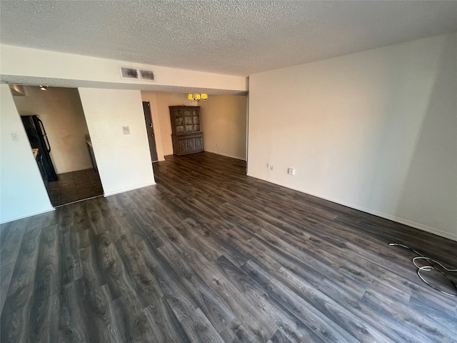 unfurnished room with dark wood-type flooring and a textured ceiling