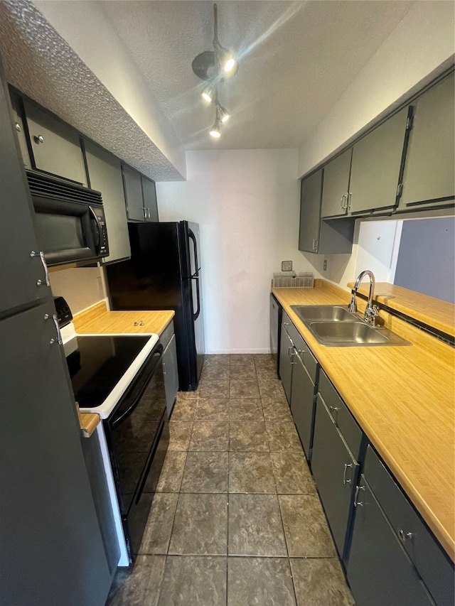 kitchen with a textured ceiling, black appliances, and sink