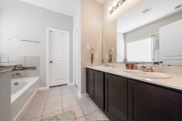 bathroom with vanity, a tub to relax in, and tile patterned flooring