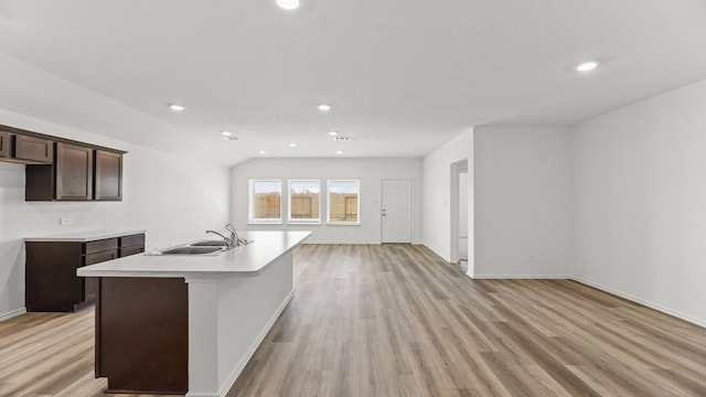 kitchen featuring a center island with sink, light wood-type flooring, and sink