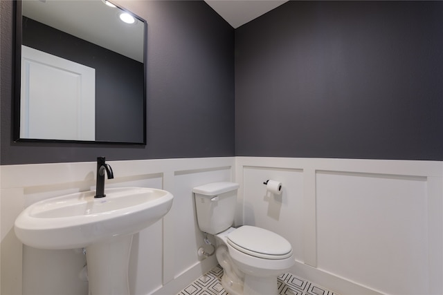 bathroom featuring tile patterned flooring, sink, and toilet