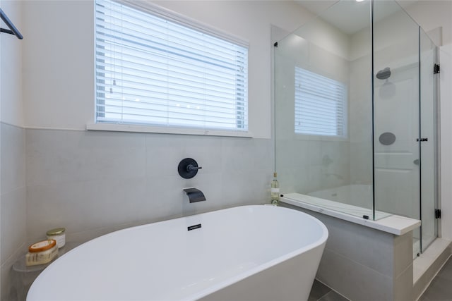 bathroom featuring tile walls, tile patterned flooring, plenty of natural light, and independent shower and bath