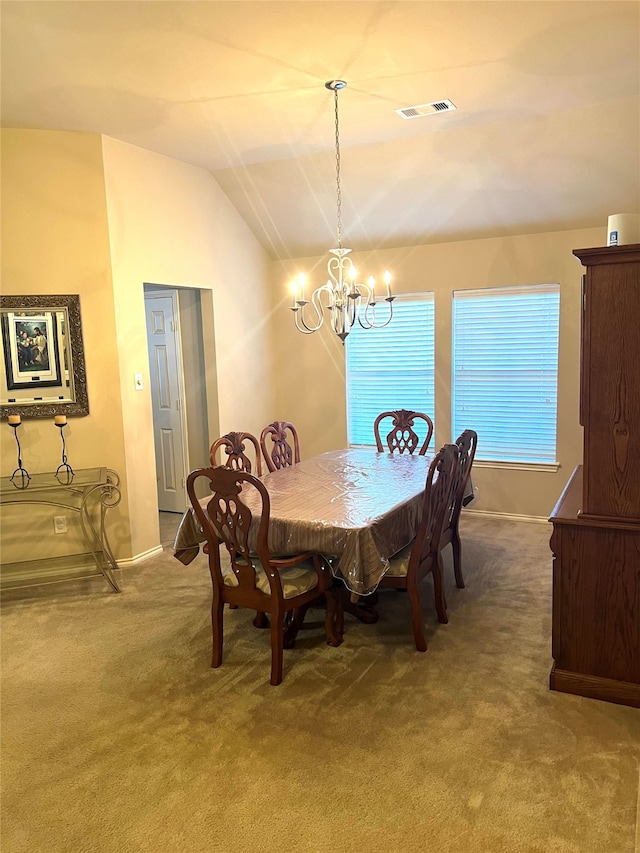 carpeted dining area with lofted ceiling and a chandelier