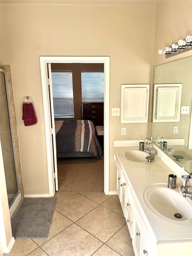 bathroom with an enclosed shower, vanity, and tile patterned flooring