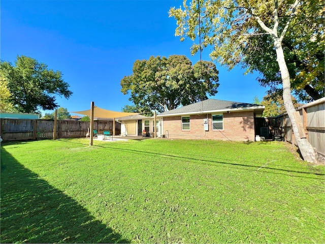 back of property with a yard and a patio area