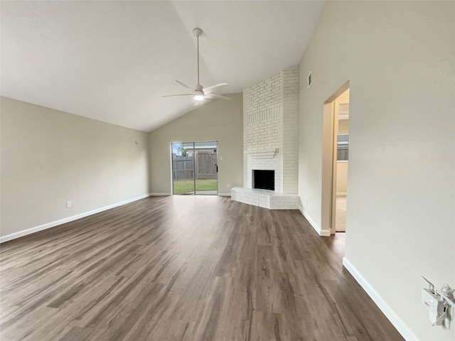 unfurnished living room with dark hardwood / wood-style flooring, high vaulted ceiling, ceiling fan, and a brick fireplace