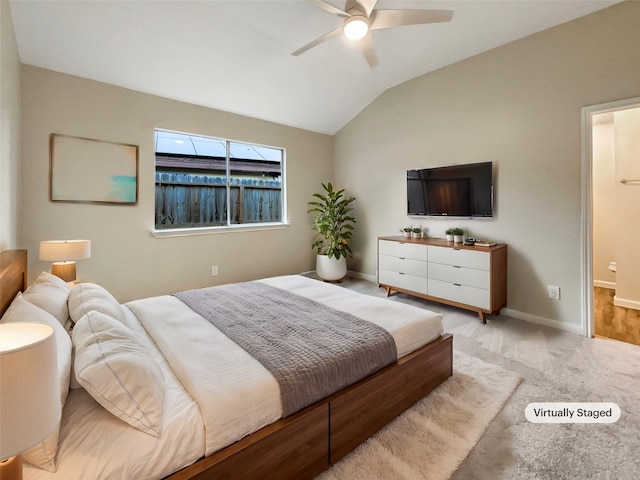 bedroom with light colored carpet, ceiling fan, ensuite bath, and vaulted ceiling